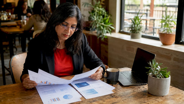 Businesswoman reviewing competitor analysis reports